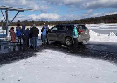 image of birders in the parking lot of the Turners Falls airport, facing away from the camera.